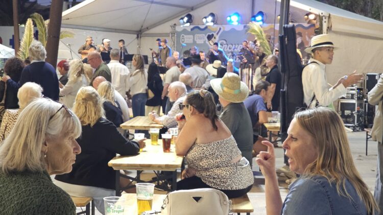Touristen kosten, tanzen und genießen die Muestra de Tradiciones Canarias in Caleta de Fuste.
